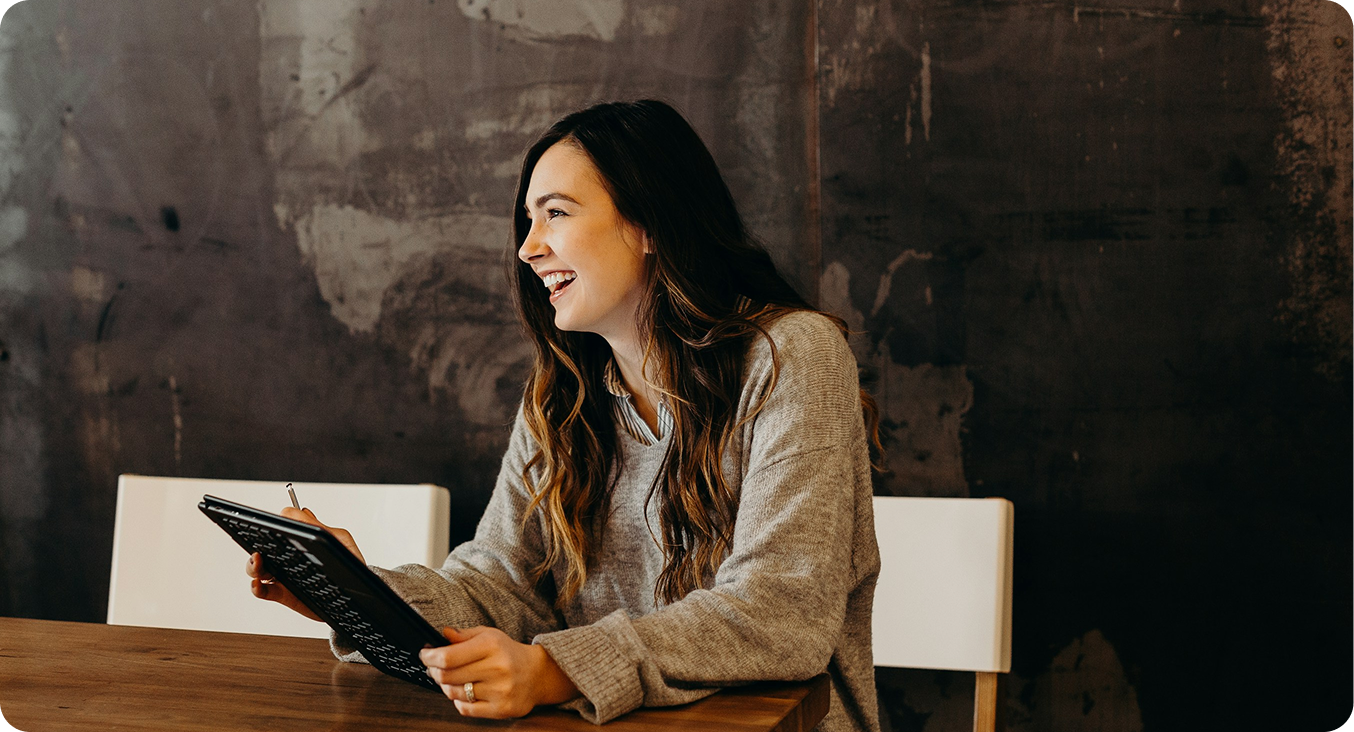 A person working at a tablet, smiling